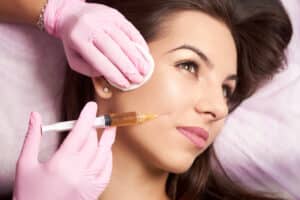 Brunette woman in her 30s receives a volumizing Restylane injection.